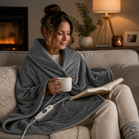 Electric heating blanket shawl used while relaxing on a sofa with controller visible