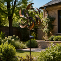 Solar powered iron wind sculpture installed in a sunny garden courtyard